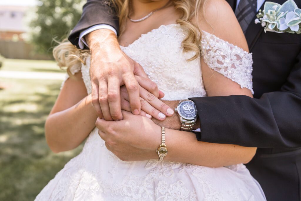 groom's arms wrapped around his bride's shoulders