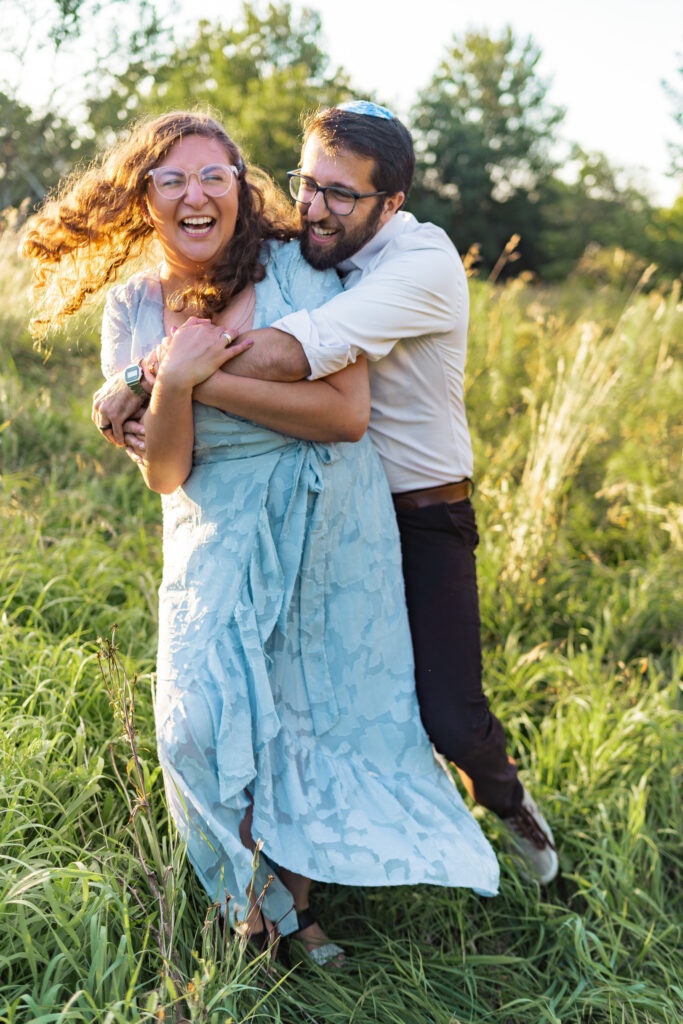 jewish couple laughing and hugging in a field Zelda's Catering