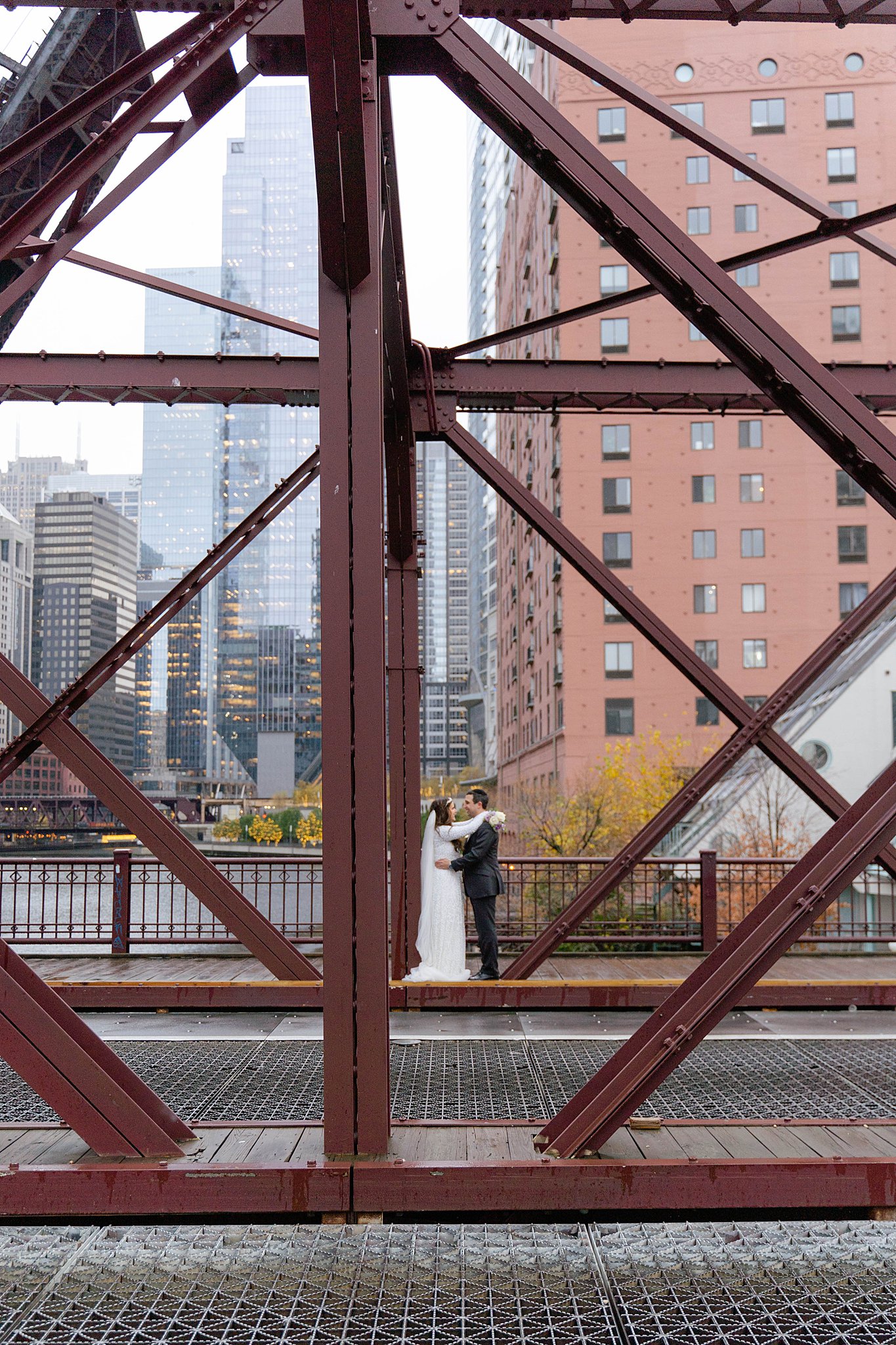 bride and groom standing on a bridge in downtown chicago