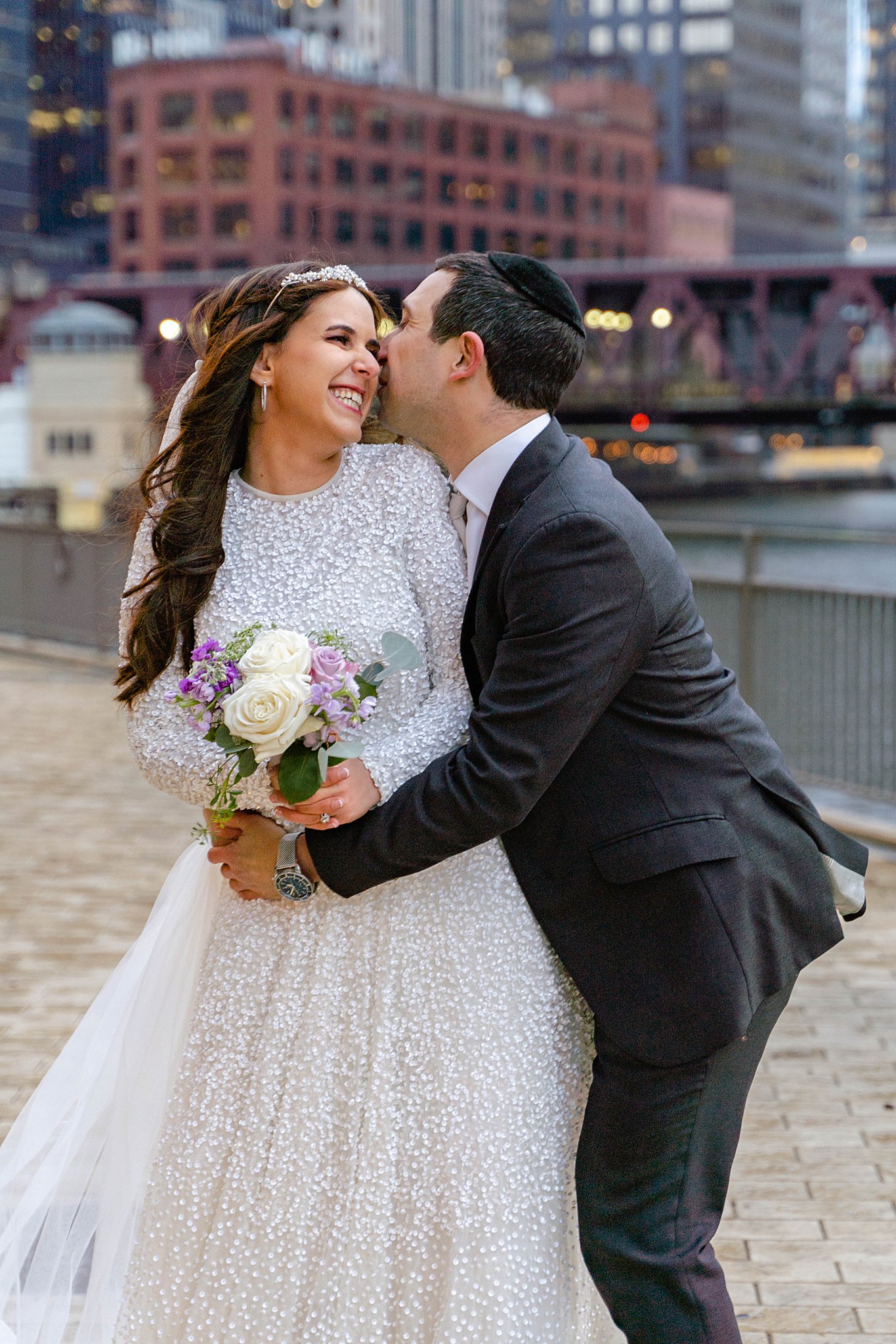 groom and bride laughing and kissing in downtown chicago celebration their Jewish Wedding Traditions