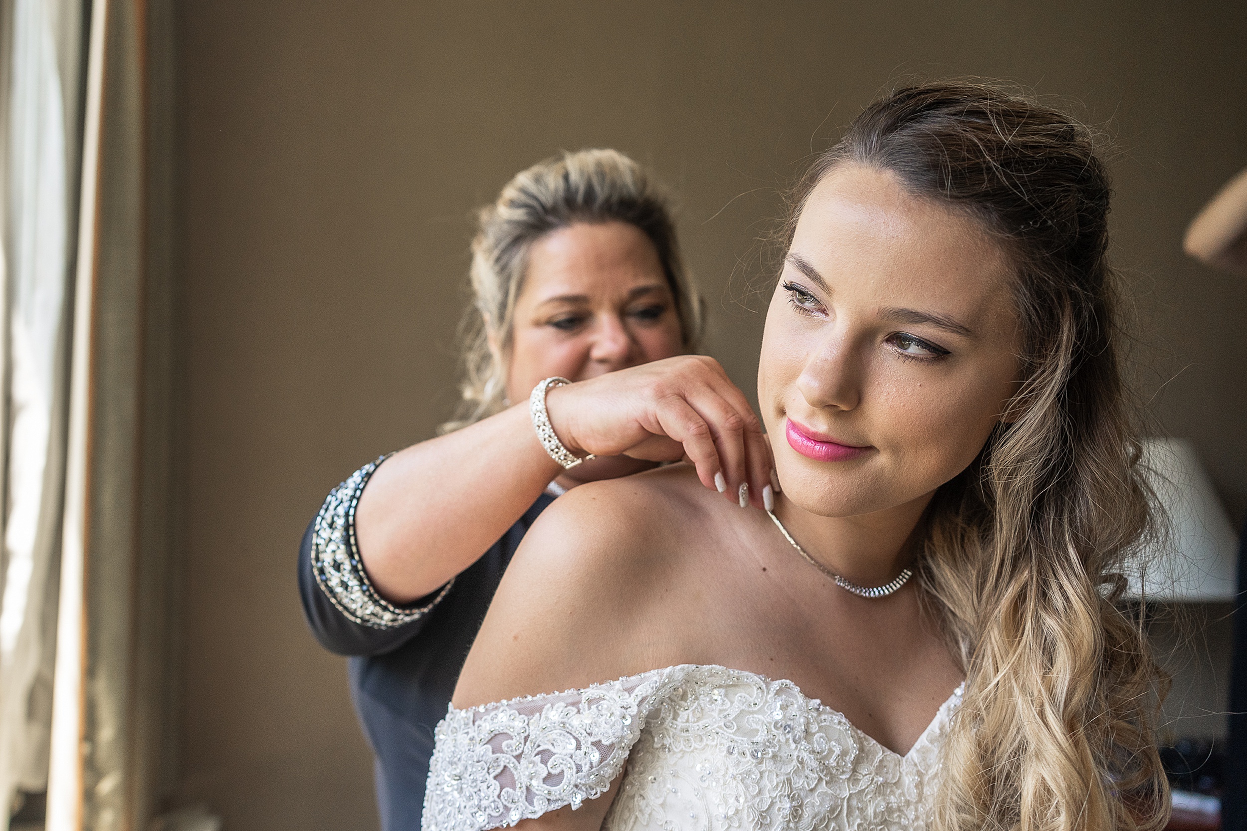 mom helping her daughter put her necklace on at chicago hotel wedding venues