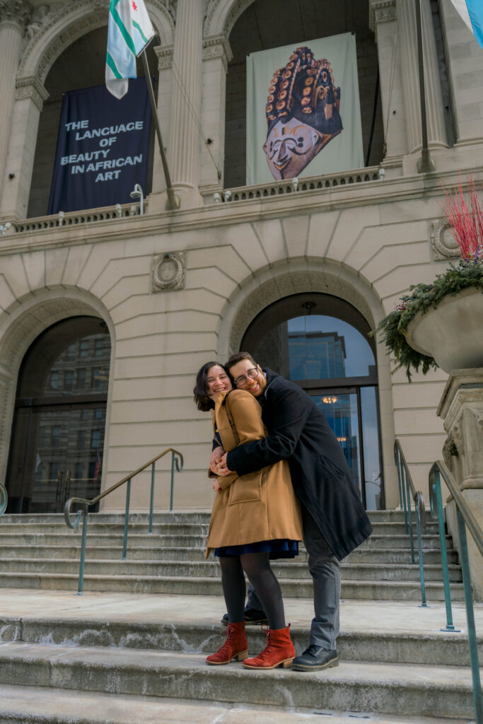 A couple hugs in front of the Art Institute Chicago