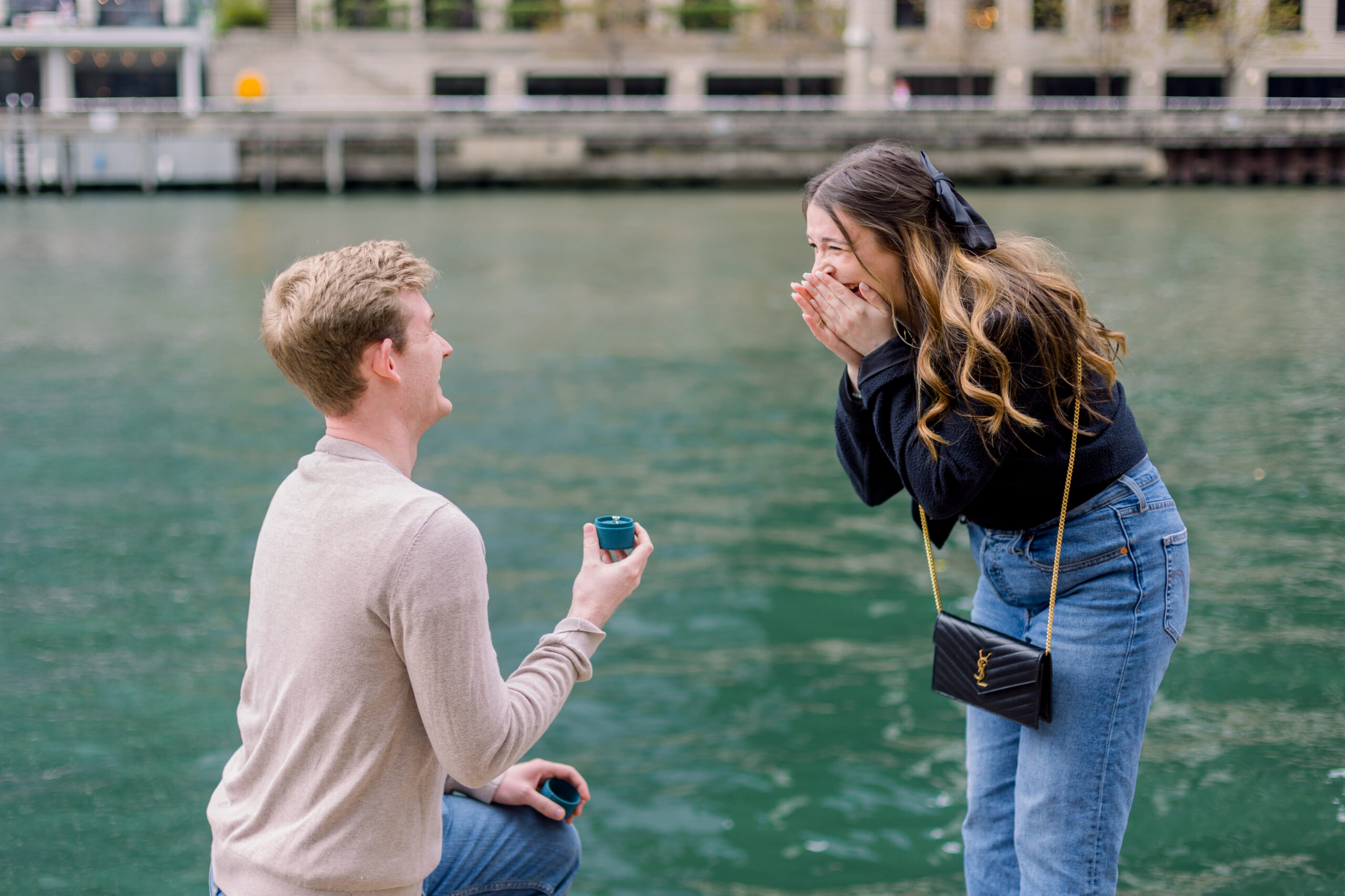 A Chicago couple stands on the riverwalk after their engagement