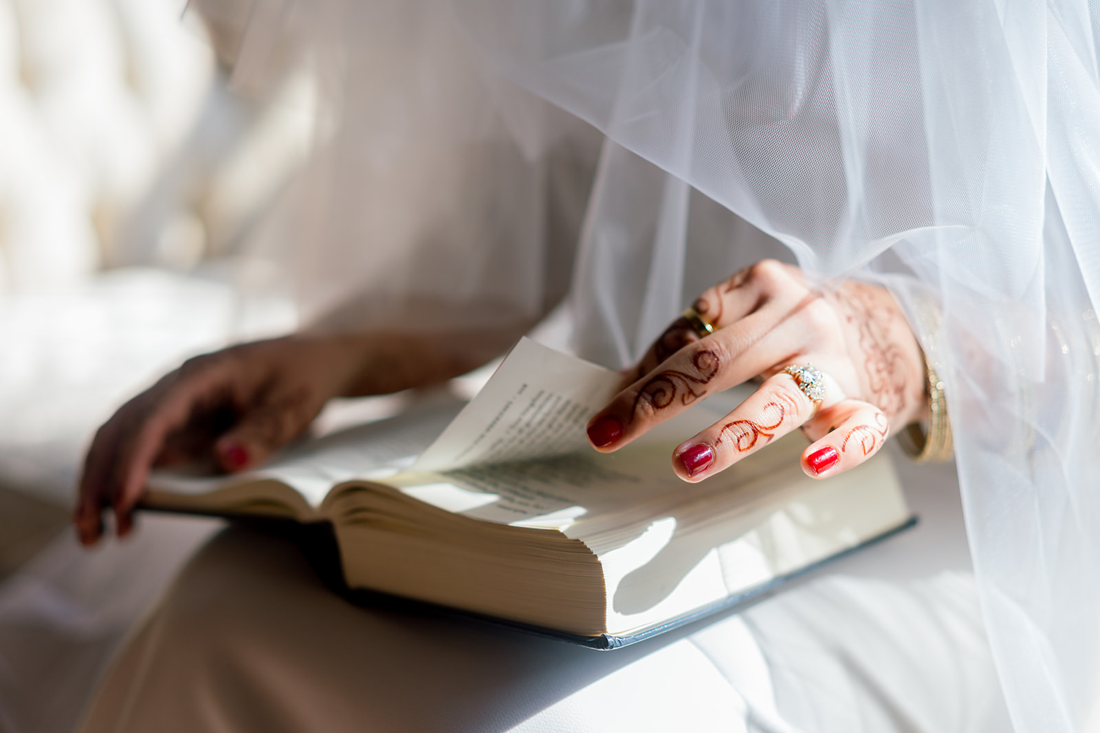 Closeup of a Jewish bride in a wedding dress holding a siddur, a Jewish prayer book.