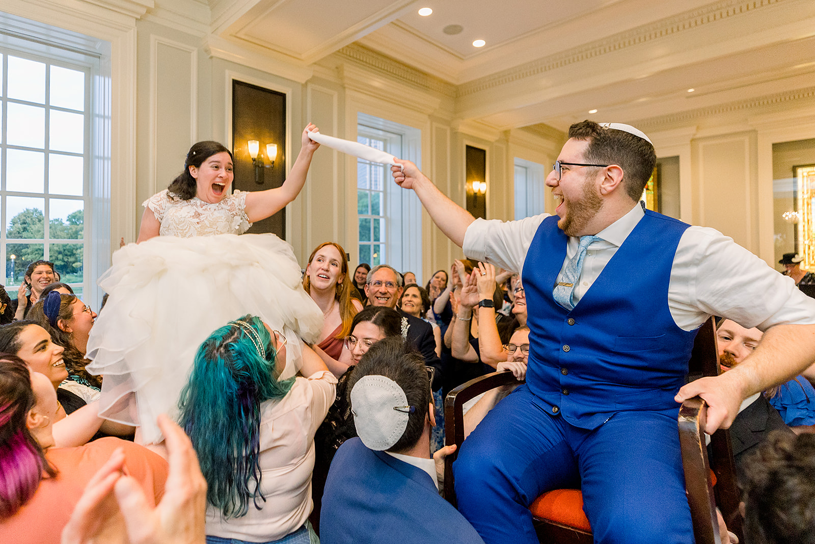 A couple is lifted on chairs during the hora at their jewish wedding