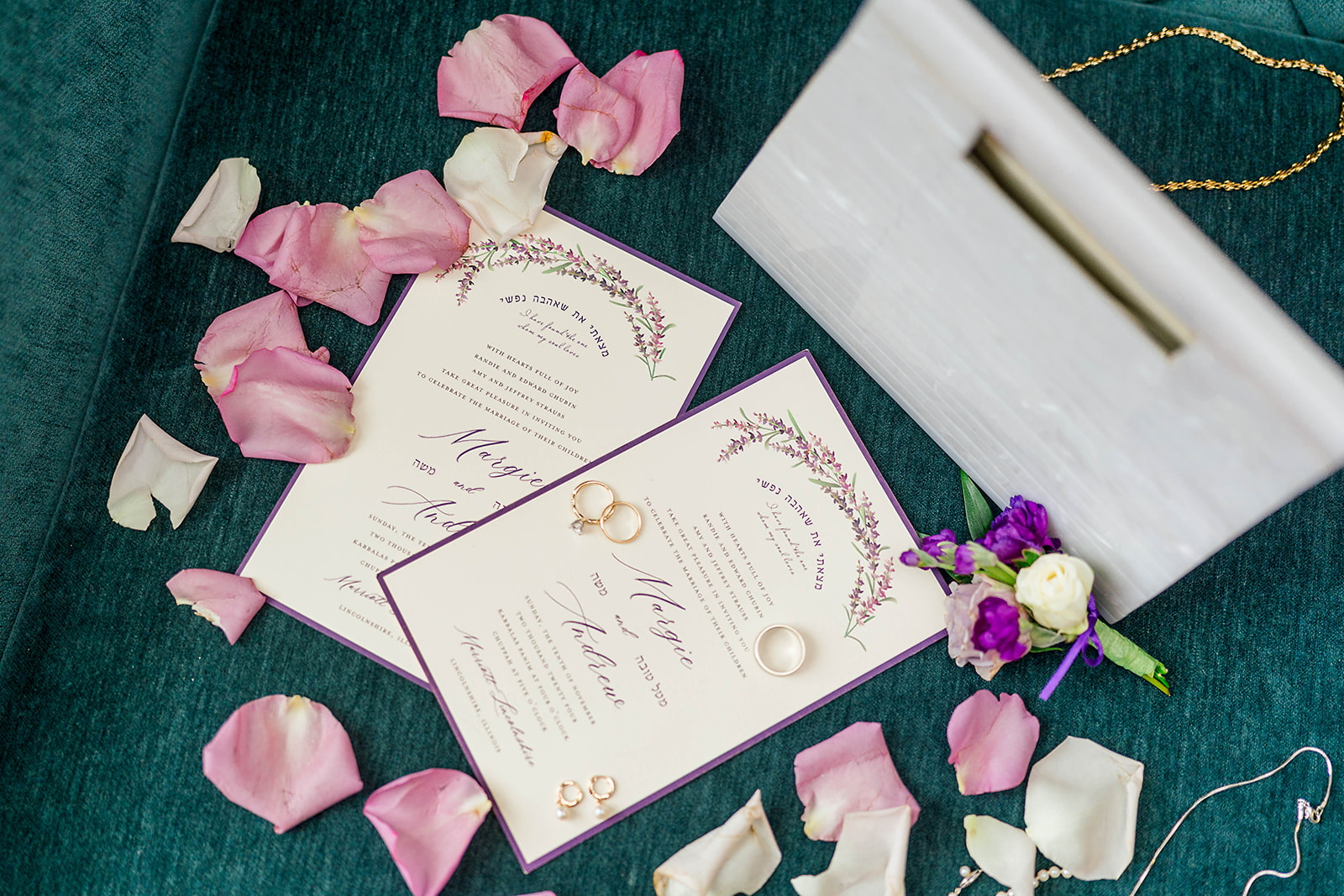 Bridal details of rings, jewelry and invitations with pink rose petals