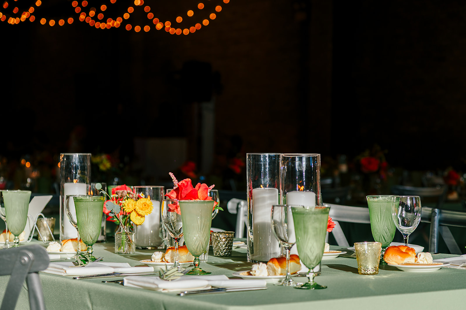 Details of a green wedding reception table setting with challah served